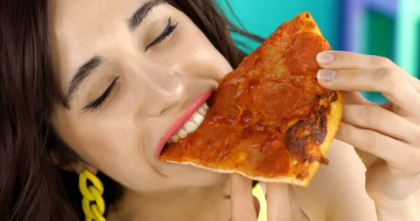 Portrait of a brunette girl eating pizza for lunch. — Stockfoto