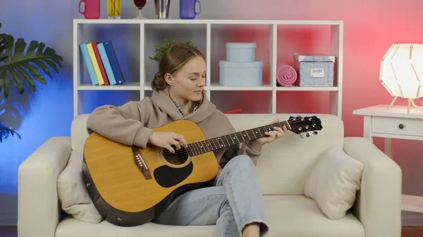 Meisje speelt akoestische gitaar thuis. Rechtenvrije Stockfoto's