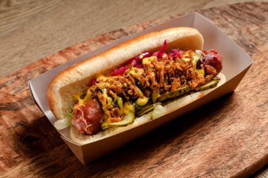 Sosisli sandviç, kızarmış soğan ve salatalık turşusu.