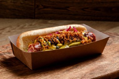 Sosisli sandviç, kızarmış soğan ve salatalık turşusu.