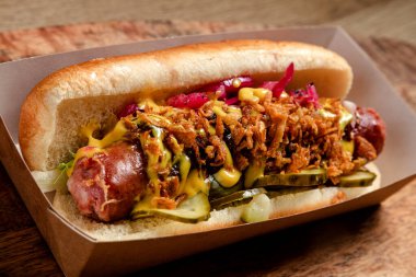 Sosisli sandviç, kızarmış soğan ve salatalık turşusu.