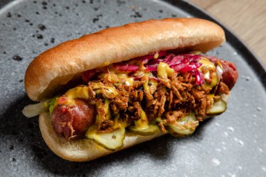 Sosisli sandviç, kızarmış soğan ve salatalık turşusu.