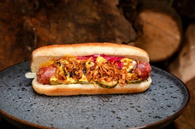 Sosisli sandviç, kızarmış soğan ve salatalık turşusu.