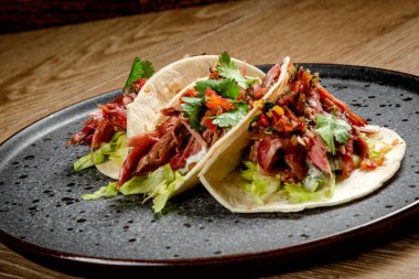 Tütsülenmiş biftek, sebze ve beyaz soslu taco.