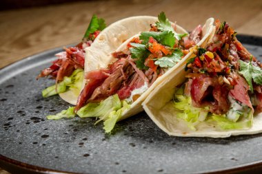 Tütsülenmiş biftek, sebze ve beyaz soslu taco.