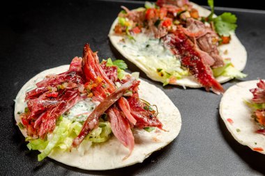 Tütsülenmiş biftek, sebze ve beyaz soslu taco.