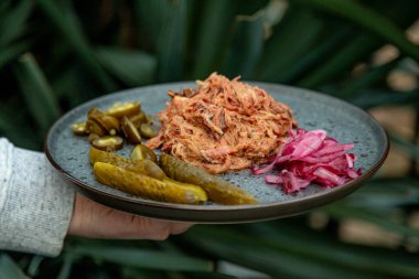 Kızarmış et, salatalık turşusu ve lahana.