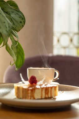 Çayla servis edilen ahududuyla süslenmiş havadar tatlı, iç kısımda tatlı.