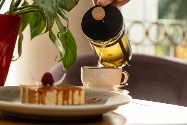 Çayla servis edilen ahududuyla süslenmiş havadar tatlı, iç kısımda tatlı.