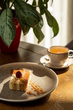 Çayla servis edilen ahududuyla süslenmiş havadar tatlı, iç kısımda tatlı.