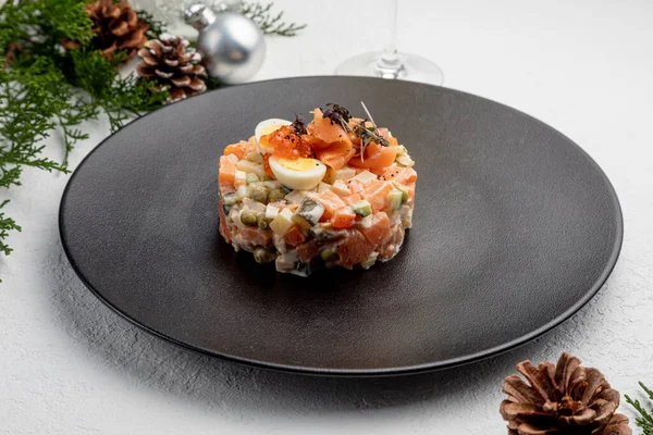 Somonlu Olivier salatası, beyaz bir Noel arkaplanı. Geleneksel Rus Yeni Yıl ve Noel Zehirlenmesi.