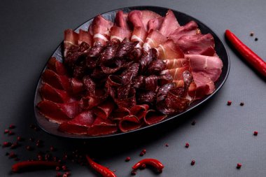 Siyah bir tabakta siyah bir arka planda soğuk kesimler.