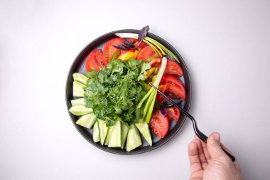 Taze sebze ve bitkilerle dolu bir tabak..