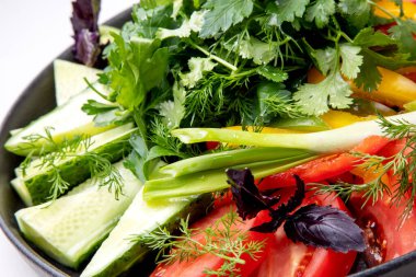 Taze sebze ve bitkilerle dolu bir tabak..