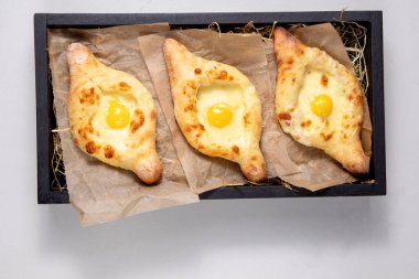 Hafif arka planda bir tabakta küçük bir khachapuri seti.