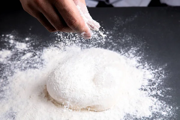 Man Sprinkles Flour Dough Table Dark Background — Stock fotografie