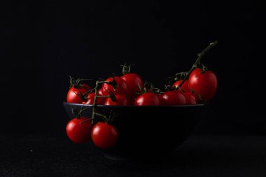 cherry tomatoes in a plate on a dark background