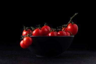 cherry tomatoes in a plate on a dark background