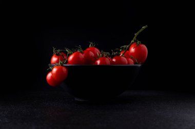 cherry tomatoes in a plate on a dark background