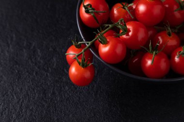 cherry tomatoes in a plate on a dark background