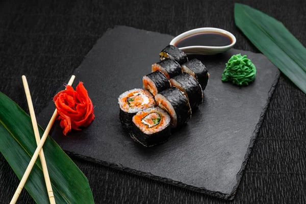 Rollos Sushi Dispuestos Sobre Fondo Oscuro Decorado Con Hojas Bambú — Foto de Stock