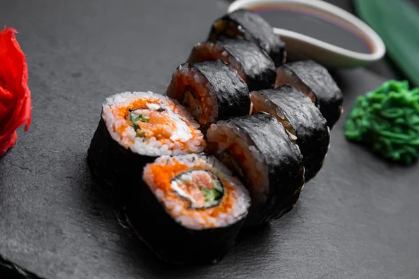Rollos Sushi Dispuestos Sobre Fondo Oscuro Decorado Con Hojas Bambú — Foto de Stock