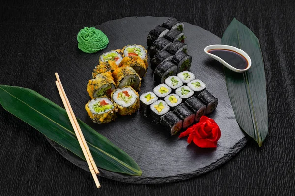 Sushi Rolls Laid Out Dark Background Decorated Bamboo Leaves Chopsticks — Stock Photo, Image