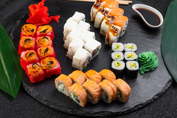 Sushi Rolls Laid Out Dark Background Decorated Bamboo Leaves Chopsticks — Stock Photo, Image