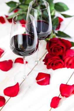 Romantik yemek. Güllü ve yapraklı iki kadeh şarap..