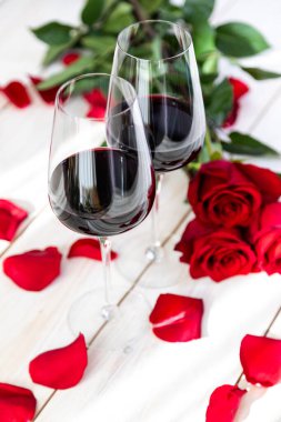 Romantik yemek. Güllü ve yapraklı iki kadeh şarap..