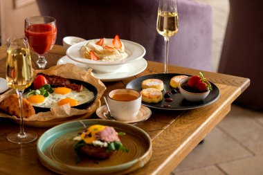 Çeşitli yemek ve içeceklerle dolu kahvaltı masası.