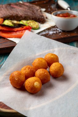 Ana yemek olarak sosla servis edilen kızarmış peynir topları.