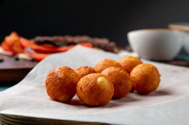 Ana yemek olarak sosla servis edilen kızarmış peynir topları.