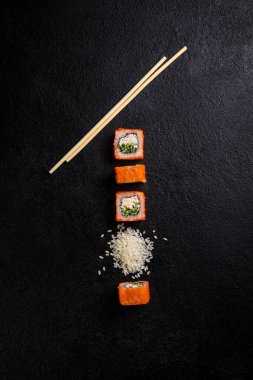 Geleneksel Japon suşi yemeği, rulo. Karanlık bir arka planda suşi.