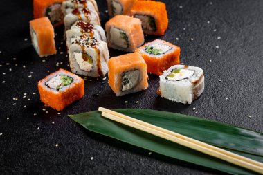 Geleneksel Japon suşi yemeği, rulo. Karanlık bir arka planda suşi.