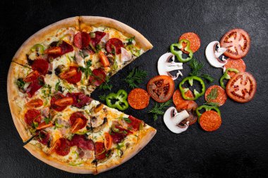Koyu arka planda malzemeli pizza.