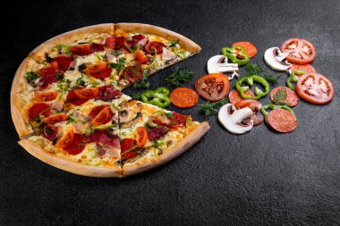 Koyu arka planda malzemeli pizza.