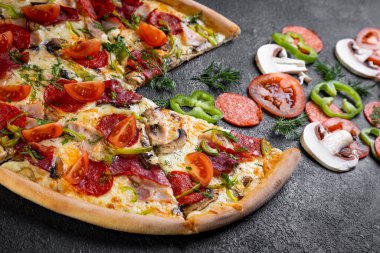 Koyu arka planda malzemeli pizza.