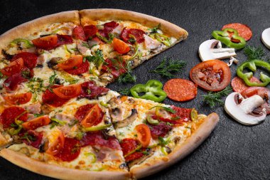 Koyu arka planda malzemeli pizza.