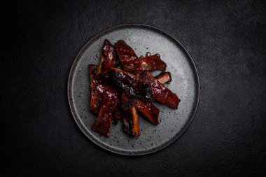 Esmer arka planda, tabakta soslu füme kaburga.