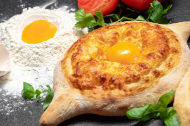 Geleneksel Gürcistan yemeği: Esmer arka planda Adjarian Khachapuri, sıcak taze hamur işi