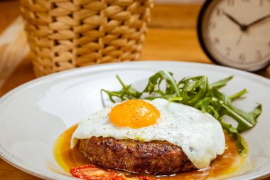 Kahvaltıda kızarmış yumurta, biftek, roka ve kurutulmuş domates.