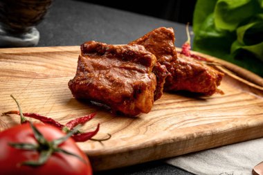 Soslu kızarmış pirzola. Koyu bir arka planda servis ediliyor.