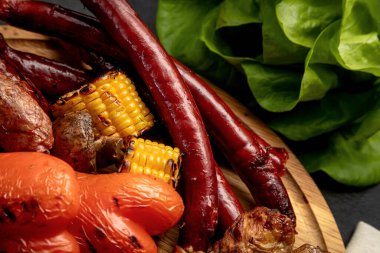 Bir tepsi ızgara ürün. Izgara biftek, ızgara sosis, ızgara sebze. Çeşit çeşit et