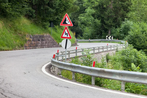 警告トラフィック署名曲がりくねった道路上の金属の棒 — ストック写真