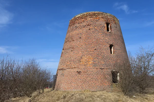 Кирпичная башня разрушена ветряной мельницей — стоковое фото