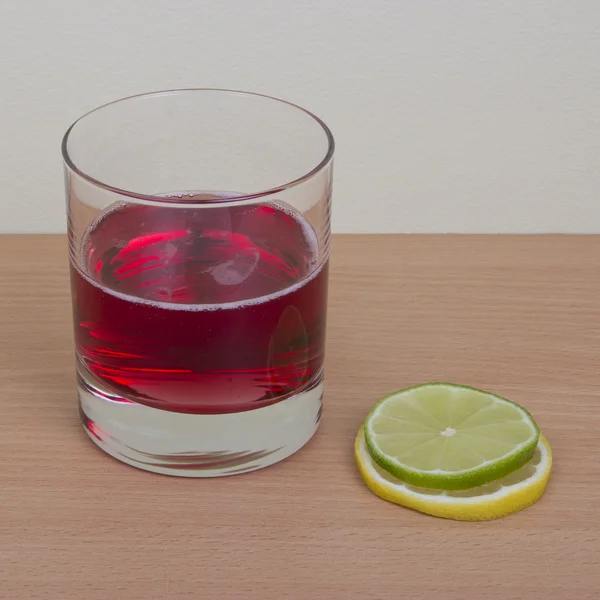 Jediné sklo s červeným nápoj, citron a linie — Stock fotografie