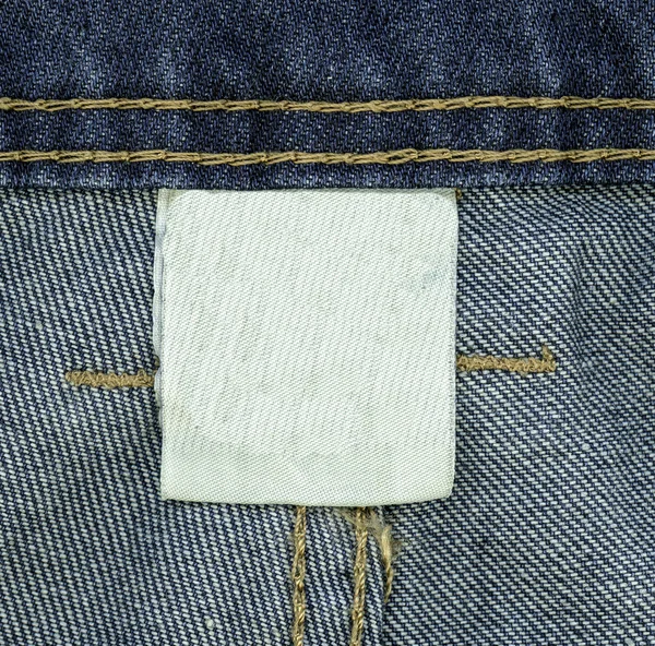 Textile blanc lable sur fond de jeans — Photo