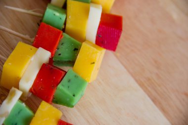 bir kesme tahtası üzerinde renkli peynirler