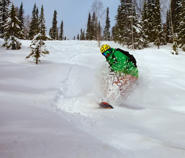 Snowboarder facendo una punta laterale intagliare con cielo blu profondo nel backgro — Foto Stock